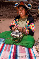 Una mujer del pueblo de Llachón vestida con un traje típico regional bordando gorros y telas muy representativas de la artesanía local. 